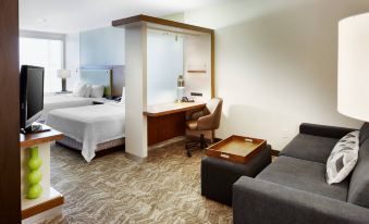 a hotel room with a bed , couch , and desk area , all neatly arranged in a modern style at SpringHill Suites Columbus OSU