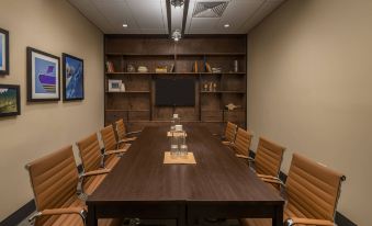 a conference room with a wooden table , chairs , and a tv on the wall , as well as a dining table nearby at Four Points by Sheraton Juneau