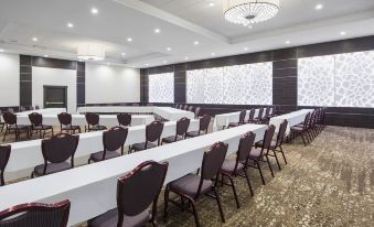 a large conference room with multiple rows of chairs arranged in a semicircle , providing seating for a large group of people at Four Points by Sheraton Chicago O'Hare