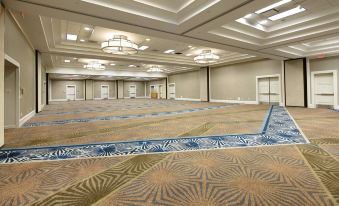 a large , empty room with a carpeted floor and multiple chandeliers hanging from the ceiling at Raleigh Marriott Crabtree Valley