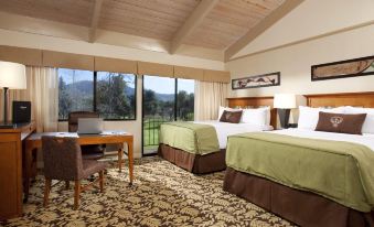 a hotel room with two beds , a desk , and a window offering a view of the outdoors at Sycuan Golf Resort
