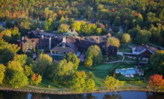 an aerial view of a large resort surrounded by trees , with a body of water in the background at Fairmont le Chateau Montebello