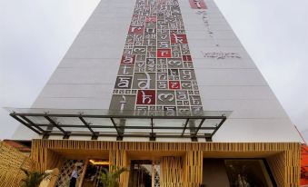 a tall building with a modern design and a large number of black and red pieces of paper hanging on the side at Imperial Heights