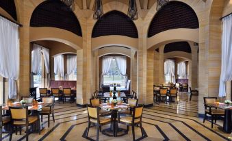 a large , open dining area with multiple tables and chairs arranged for a group of people to enjoy a meal at Marriott Mena House, Cairo