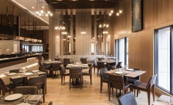 a modern , minimalist restaurant with wooden floors and walls , large windows , and several dining tables at Hotel Valletta
