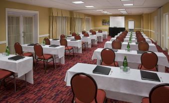 a conference room set up for a meeting , with rows of chairs arranged in a semicircle around a table at Residence Inn Gravenhurst Muskoka Wharf