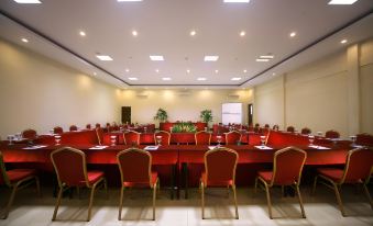 a large conference room with multiple rows of red chairs arranged in a semicircle around a long table at Aston Sunset Beach Resort - Gili Trawangan