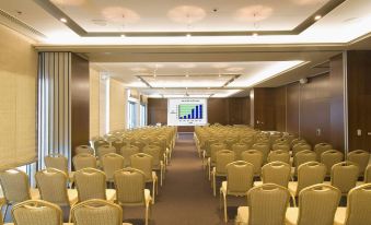 a large conference room with rows of chairs arranged in a semicircle , and a projector screen at the front of the room at Admiral Grand Hotel
