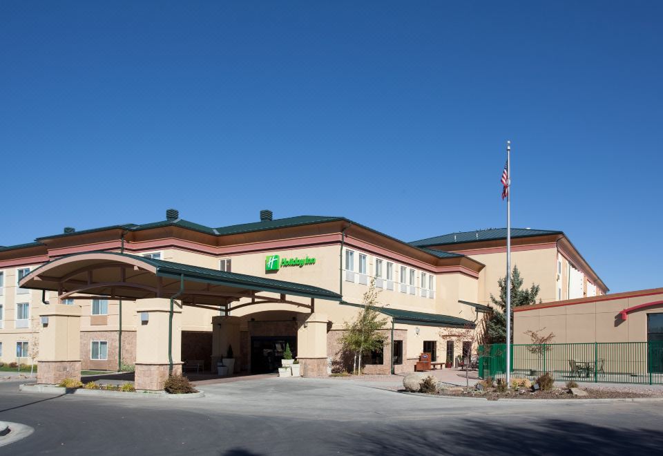 "a large building with a green sign that reads "" holiday inn express "" prominently displayed on the front" at Holiday Inn Rock Springs