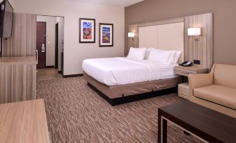 a large bed with white linens is in a room with carpeted floors and two nightstands at Holiday Inn Express & Suites Williams