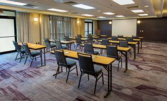 a conference room with rows of chairs arranged in a semicircle , and a projector on the wall at Courtyard by Marriott Scranton Montage Mountain