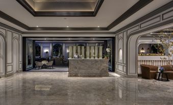 a luxurious hotel lobby with marble flooring , a large reception desk , and several chairs arranged around it at InterContinental Sydney Double Bay, an IHG Hotel