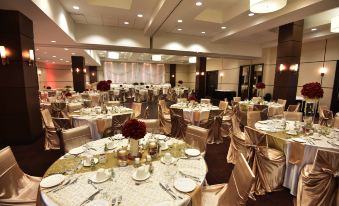 a large banquet hall filled with tables and chairs , ready for a wedding or special event at Four Points by Sheraton Winnipeg South