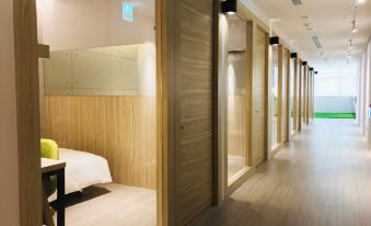 a hotel room with wooden walls and a row of bunk beds on the right side at Hub Hotel