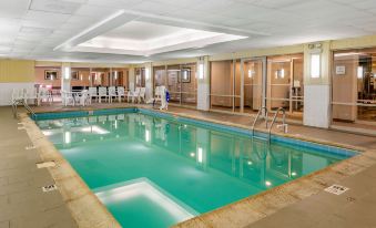 an indoor swimming pool with a tiled floor , surrounded by white walls and a glass ceiling at Comfort Suites Oakbrook Terrace Near Oakbrook Center