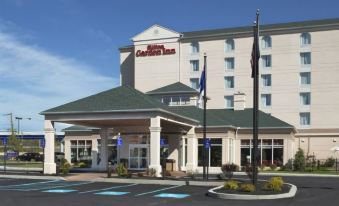 a large hotel with a red sign on the side and flags flying in front of it at Hilton Garden Inn Philadelphia/Ft. Washington