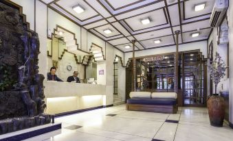 "a modern hotel lobby with marble floors , white walls , and a reception desk that says "" hotel on "" in black letters" at Garden Hotel