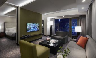 a modern living room with a large flat - screen tv mounted on the wall , surrounded by comfortable seating at Paradise Hotel Busan