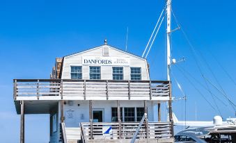 "a large white building with a sign that says "" daniafen "" is situated on a dock , and boats docked nearby" at Danfords Hotel & Marina