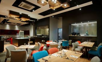 a modern restaurant with various dining tables and chairs , creating an inviting atmosphere for customers at Kip Hotel