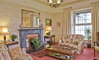 a living room with a fireplace , red carpet , and floral patterned furniture in front of a window at Ees Wyke Country House
