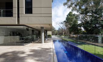 a modern house with a large glass window and a swimming pool in the backyard at Knightsbridge Canberra