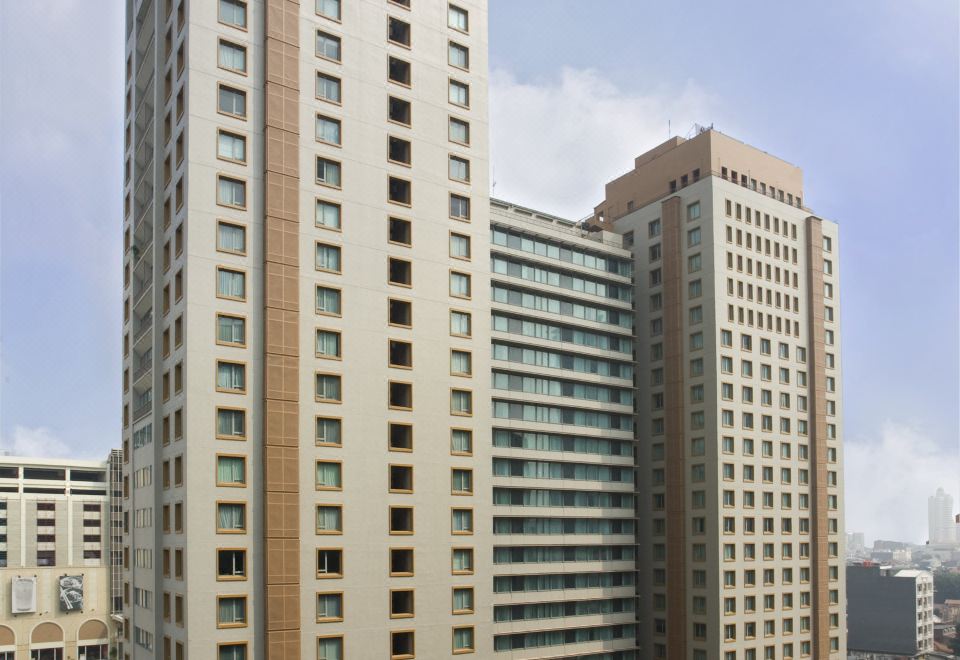 a tall building with a large glass window and an inset on the side of it at Ascott Jakarta