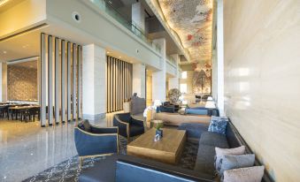 a modern hotel lobby with a seating area and a large chandelier hanging from the ceiling at Alila Solo