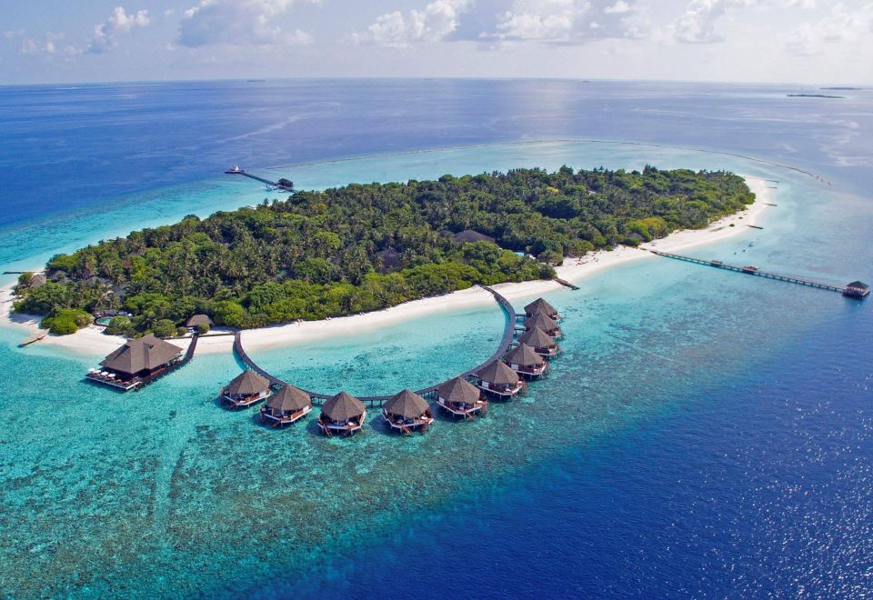 aerial view of a tropical island with palm trees and a small island with thatched - roof huts at Adaaran Select Meedhupparu - with 24Hrs Premium All Inclusive