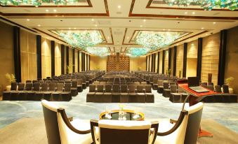 a large conference room with rows of chairs arranged in a symmetrical fashion , and a podium at the front at Crowne Plaza New Delhi Mayur Vihar Noida