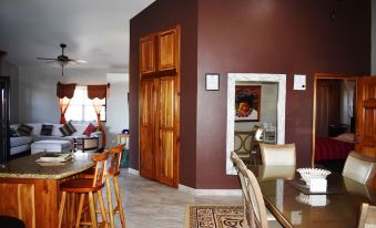 a dining room with a wooden table and chairs , a wine cabinet , and a kitchen area at Lucina's
