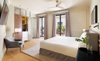 a spacious bedroom with a large bed , hardwood floors , and a balcony overlooking the city at H10 Palacio Colomera