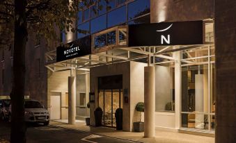 "the entrance to a hotel with a sign that says "" novotel "" and people entering through the doorway" at Novotel Chateau de Versailles