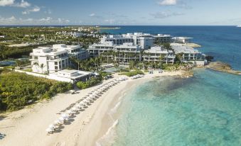 aerial view of a beach with a hotel in the background , surrounded by sand and water at Four Seasons Resort and Residence Anguilla