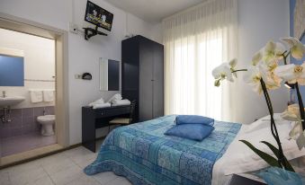 a modern bedroom with a large window , a tv on the wall , and a bed with blue bedding at Hotel Milano