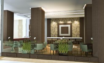a modern restaurant with a bar area and dining tables , featuring green chairs and wooden tables at Tjokro Hotel Klaten