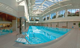 an indoor swimming pool with a glass roof , allowing natural light to fill the space at Hotel Grand Pacific