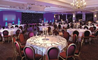 a large banquet hall with multiple tables and chairs set up for a formal event at Macdonald Inchyra Hotel and Spa