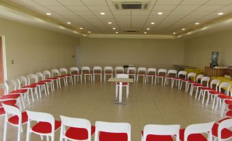 a room with a circle of white chairs and red cushions , surrounded by a table at Atami Escape Resort