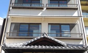 a tall white building with many windows and balconies , as well as a covered entrance at Sakuraya