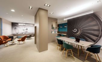 a modern office space with a long table and chairs , a large window , and a spiral - patterned wall mural at NH Vienna Airport Conference C