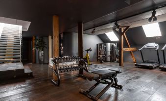 a gym with various exercise equipment , including a weightlifting machine and a treadmill , is shown in this image at Hotel Weitzer Graz