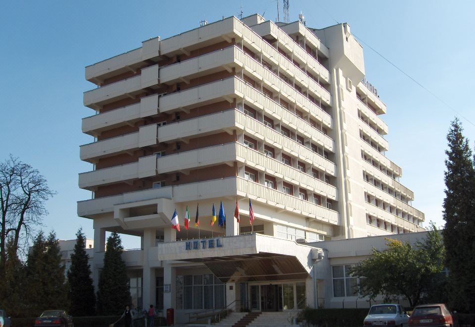 a large white hotel building with multiple floors , situated in front of a clear blue sky at Hotel Belvedere