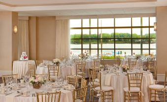 a large room with tables and chairs set up for a wedding reception , overlooking a body of water at Sheraton Portsmouth Harborside Hotel