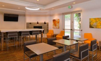 a modern and well - lit lobby area with various seating options , including couches , chairs , and tables at Residence Inn Palo Alto Los Altos