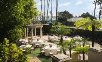 a courtyard with several round tables and chairs set up for an outdoor event , possibly a wedding reception at The Ritz-Carlton, Marina del Rey