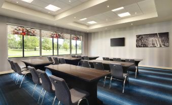 a conference room with rows of chairs and tables , a large screen on the wall , and framed art on the ceiling at Aloft Hillsboro-Beaverton