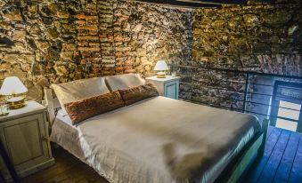 a cozy bedroom with a brick wall , a bed , and a lamp on the nightstand at Santa Virginia