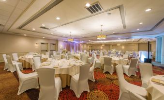 a large banquet hall with multiple tables and chairs set up for a formal event at Hotel Mtk Mount Kisco