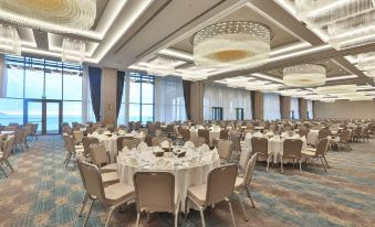 a large banquet hall with multiple round tables and chairs arranged for a formal event at Radisson Blu Hotel Trabzon